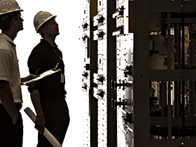 man in hard hat looking at rack enclosures