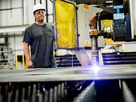 Man in hard hat observing welding machine